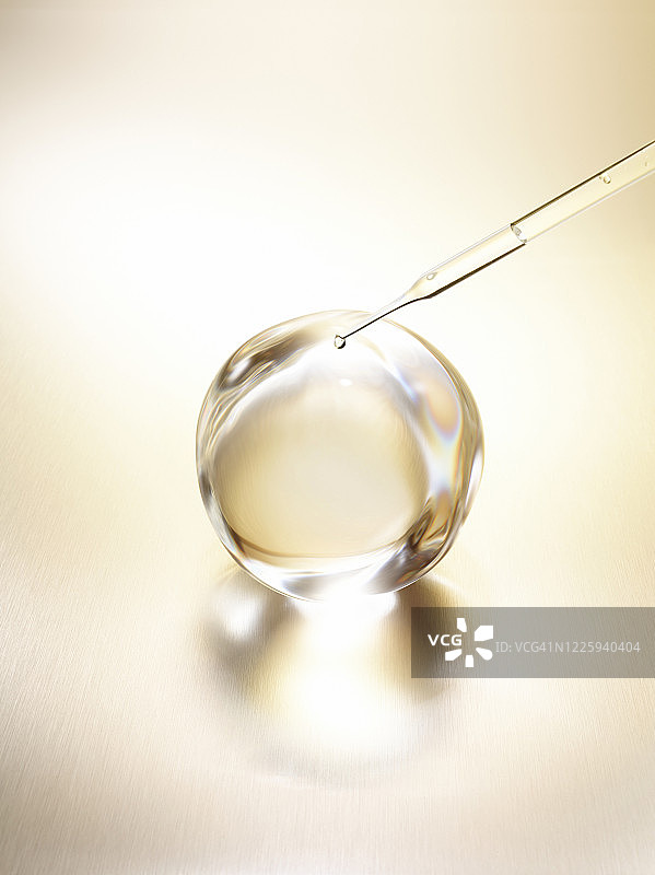 金色金属表面水滴反射及移液器45度角特写图片素材