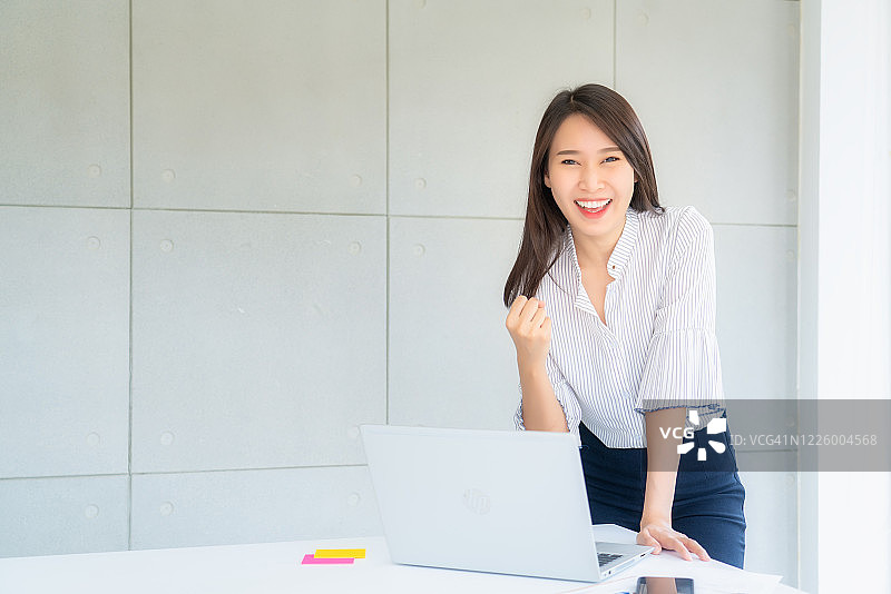 女商人在办公室举手；成功理念图片素材