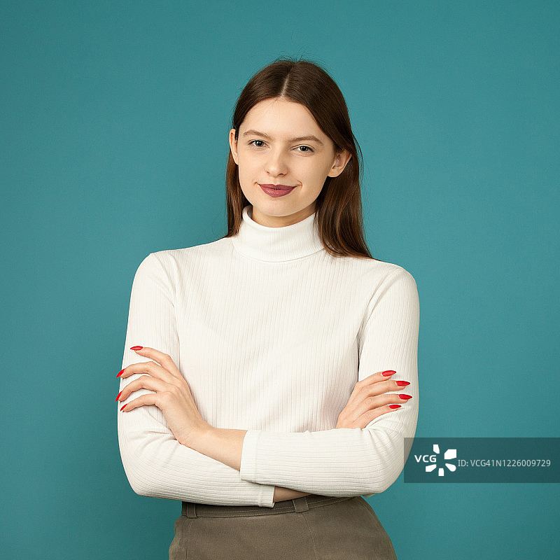 蓝色背景上的20岁女子影室肖像图片素材