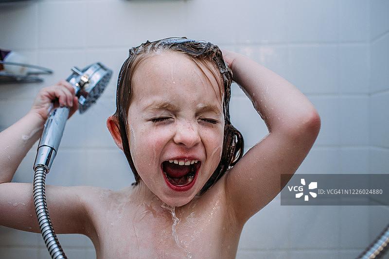 近距离的一个孩子在淋浴时唱歌洗头发图片素材