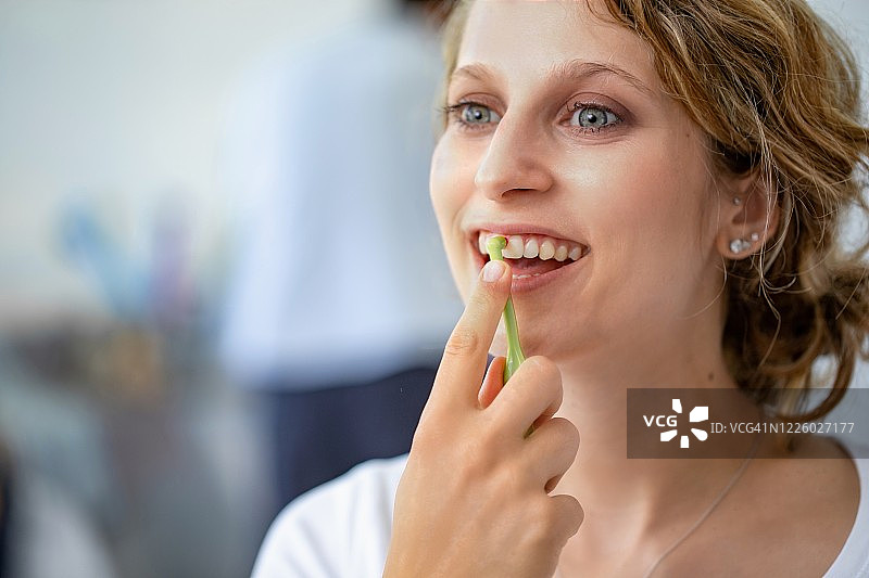 早上快乐的年轻妇女使用牙间刷的肖像-库存照片图片素材