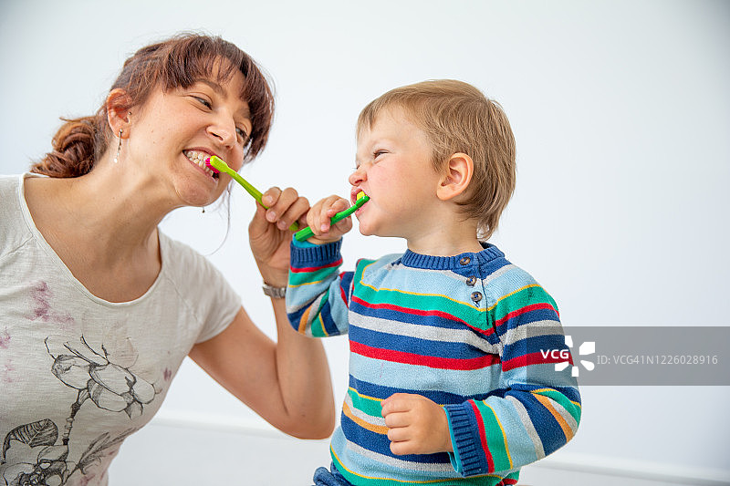 父母和孩子一起刷牙时做鬼脸（白色背景）图片素材