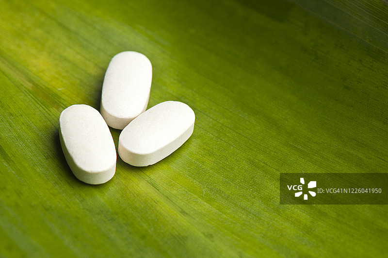 羟氯喹药丸在绿叶上的特写图片素材