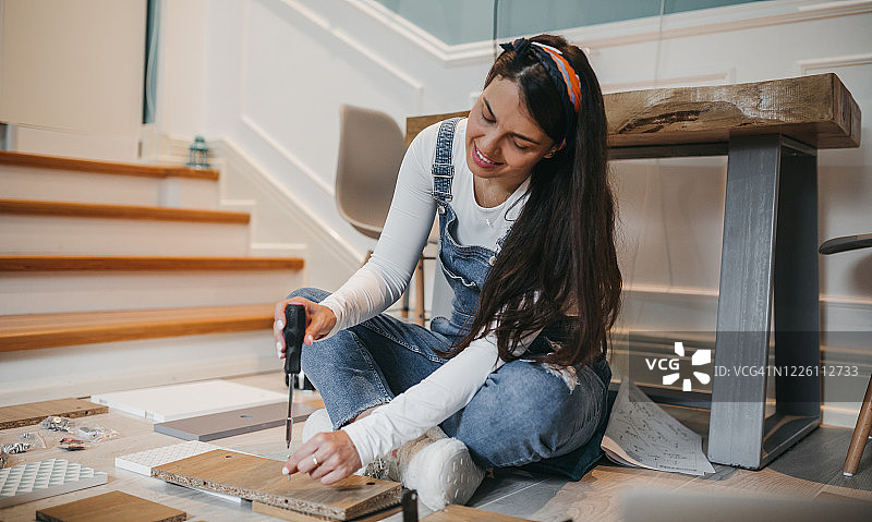 年轻的女雕塑家正在她的工作室里工作图片素材