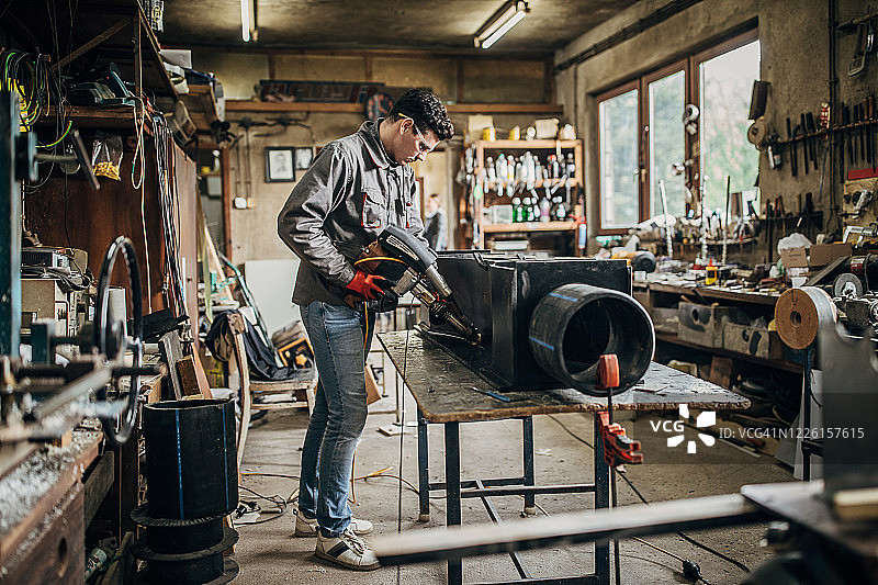 在车间焊接水槽的年轻工匠图片素材