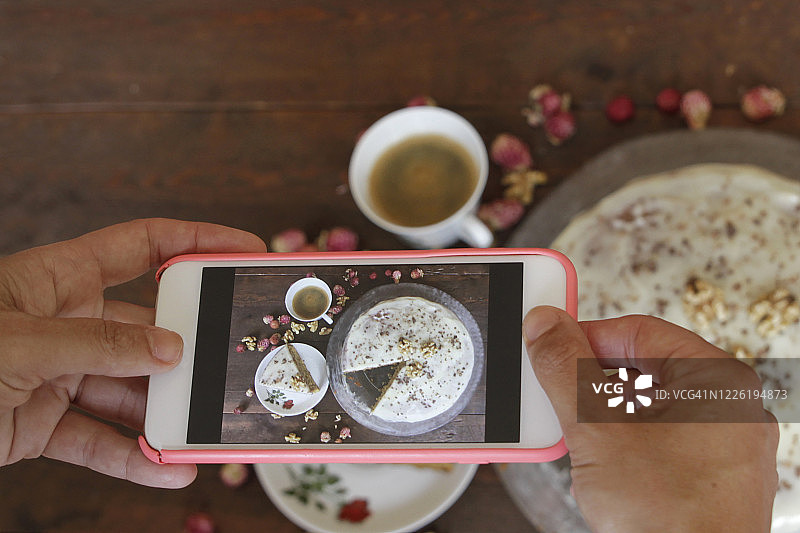 女人用手拍摄胡萝卜蛋糕图片素材