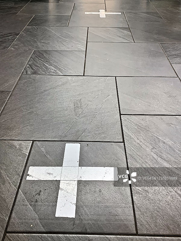 冠状病毒疫情期间零售店地板上的胶带标记图片素材