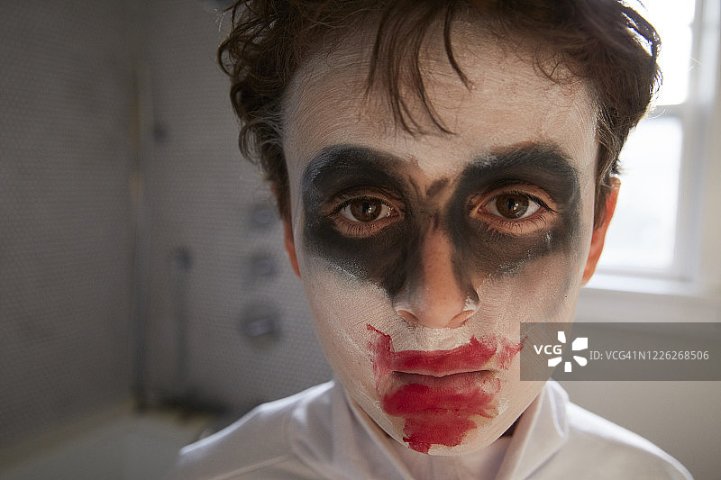 棕色卷发棕色眼睛的男孩，化着万圣节妆容，近距离面对镜头，选择性聚焦，窗台在他身后，凌乱的卷发，化妆舞会妆容图片素材