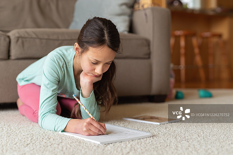 疫情隔离期间在家做功课的年轻女孩图片素材