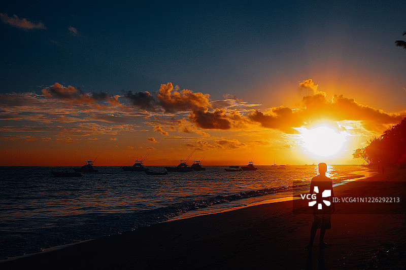 男子在海滩上享受日落图片素材