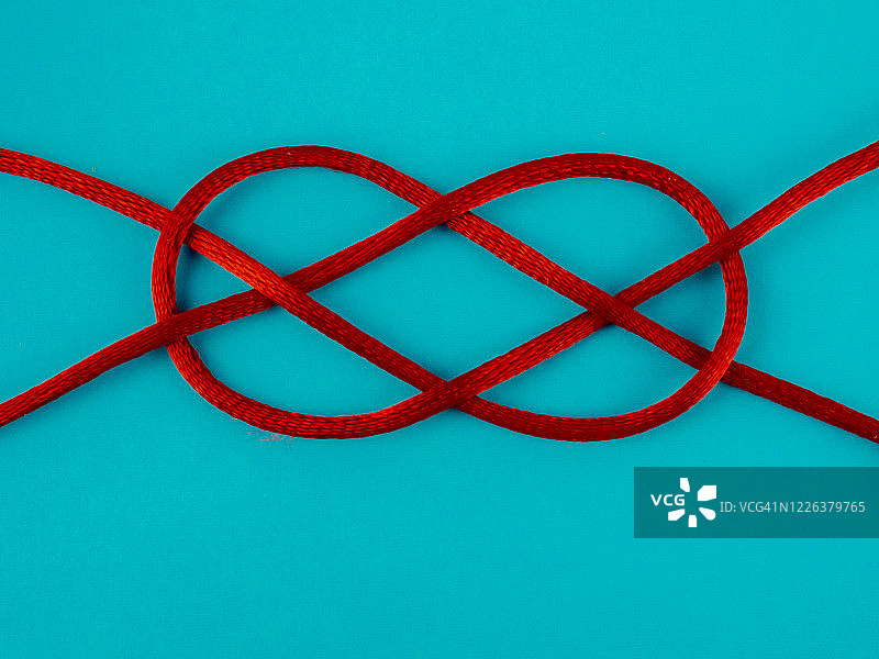 蓝色背景红色细绳上的水手结图片素材