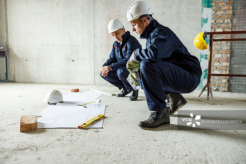 翻新现场两名施工工人分析蓝图图片素材
