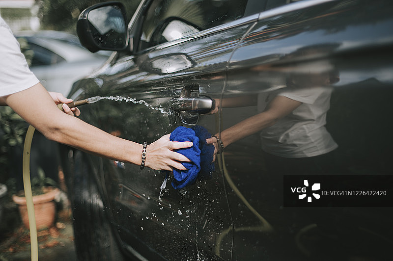中国青少年男孩在自家门前洗车图片素材