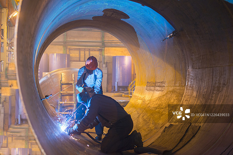 两名焊工在石油管道内工作图片素材