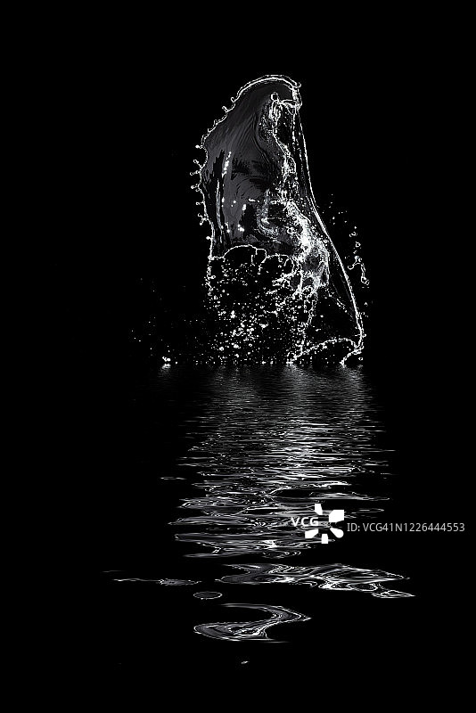 漂浮在空中并倒映在黑色背景水中的水形象和抽象形式图片素材