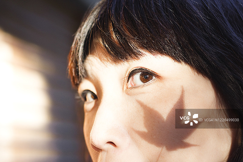 女人脸颊上的枫叶阴影图片素材