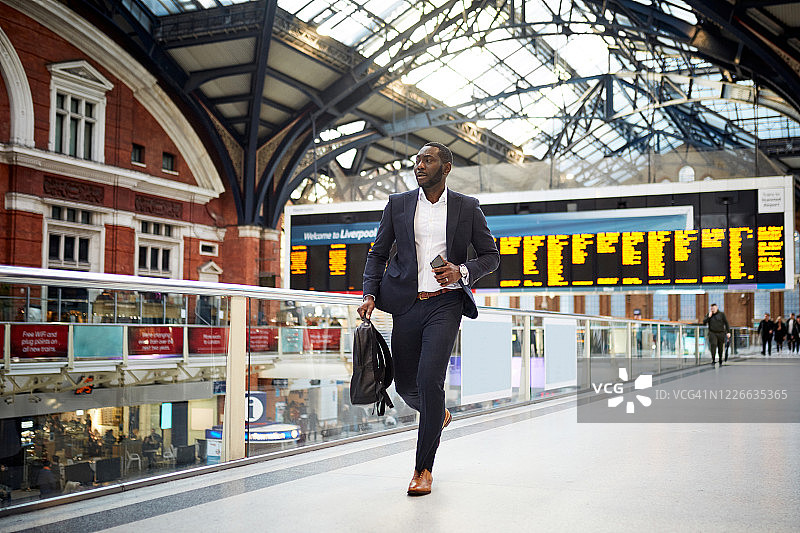 在伦敦火车站奔跑的非洲商人图片素材