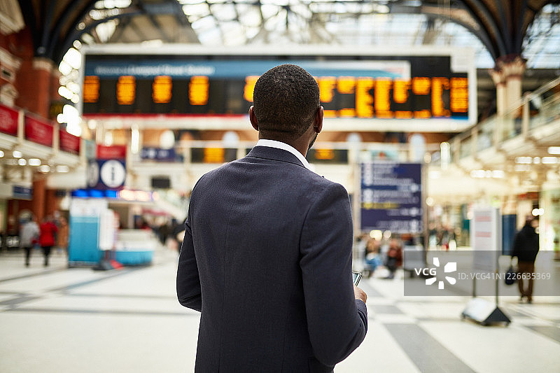 非洲行政人员查看到达/离开板上的时间图片素材