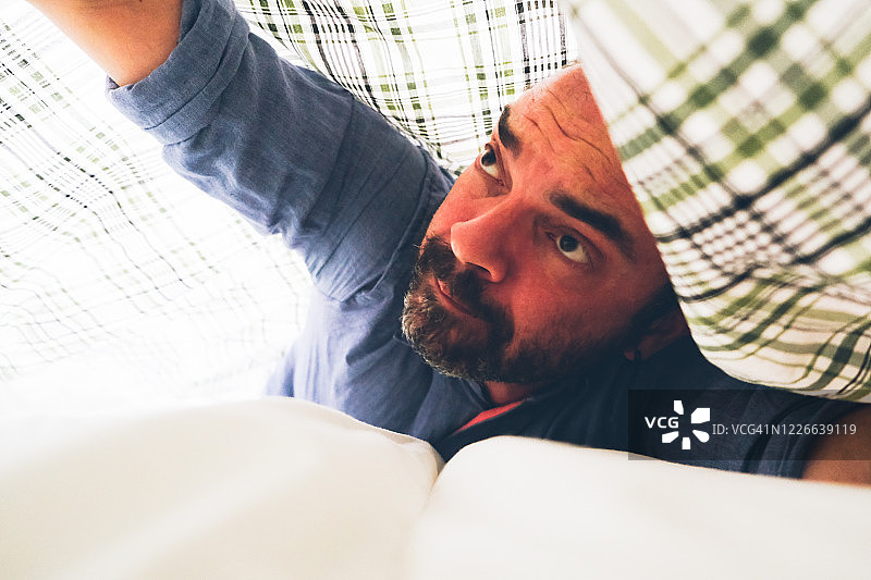 男人试图套被子图片素材