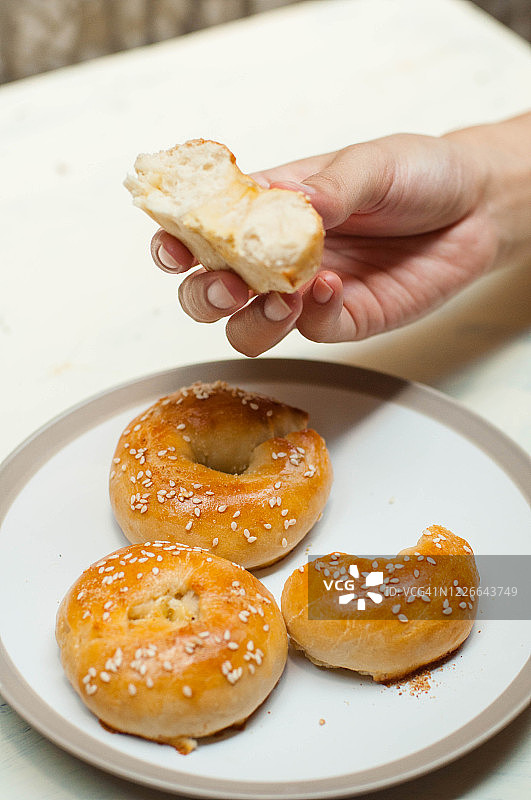 年轻人正在品尝新鲜出炉的百吉饼图片素材