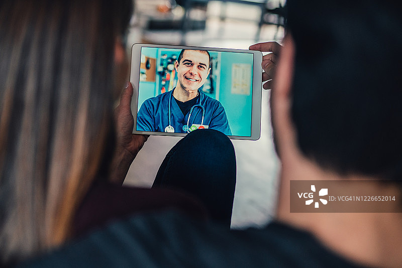 年轻情侣在线交流家庭医生图片素材