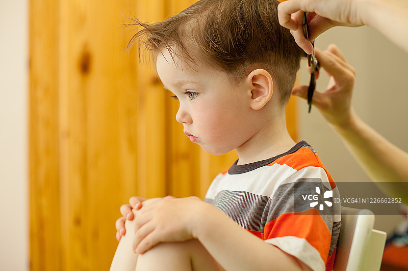 女人给3岁的儿子理发图片素材