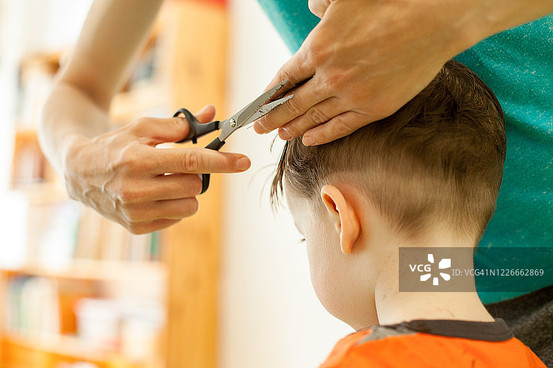 女人给3岁的儿子理发图片素材