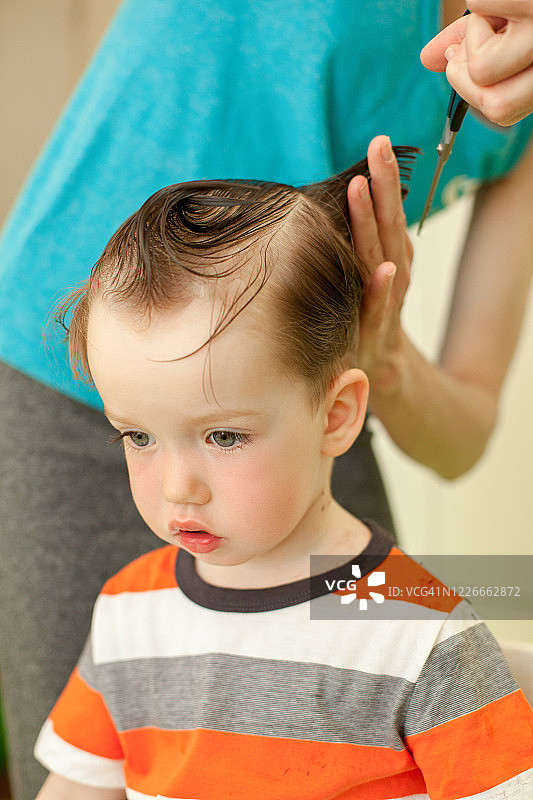 女人给3岁的儿子理发图片素材