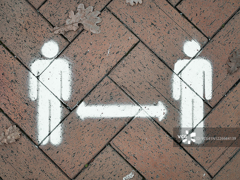 人行道上喷绘的保持社交距离标志图片素材