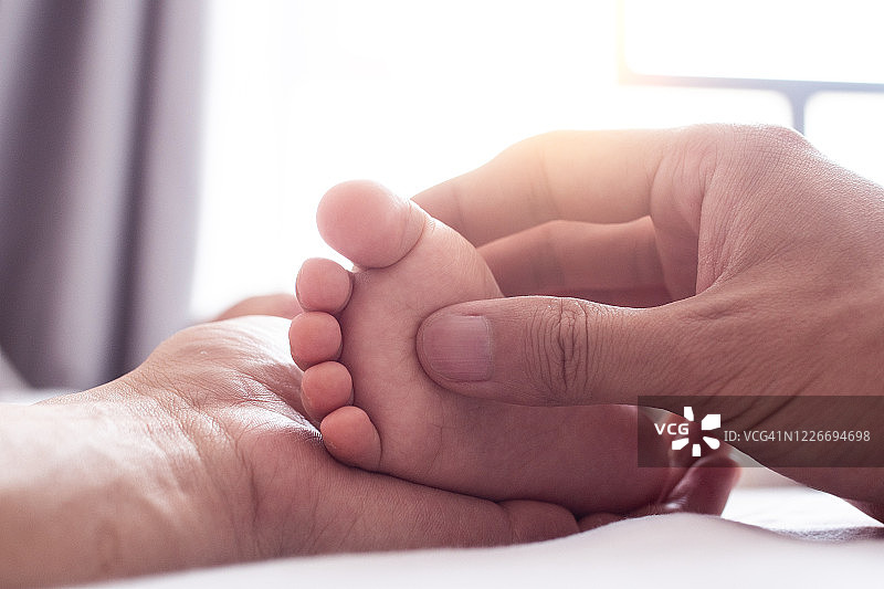 母亲握着婴儿的脚图片素材