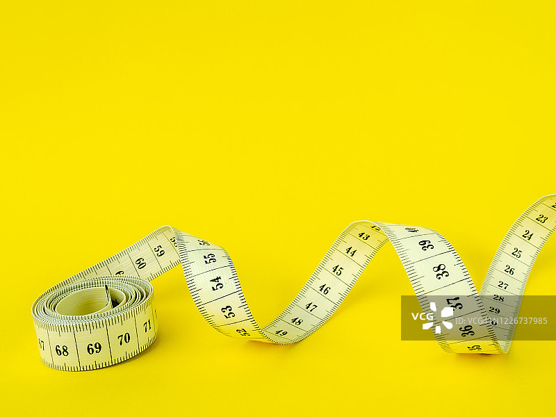 黄色背景上的卷尺图片素材