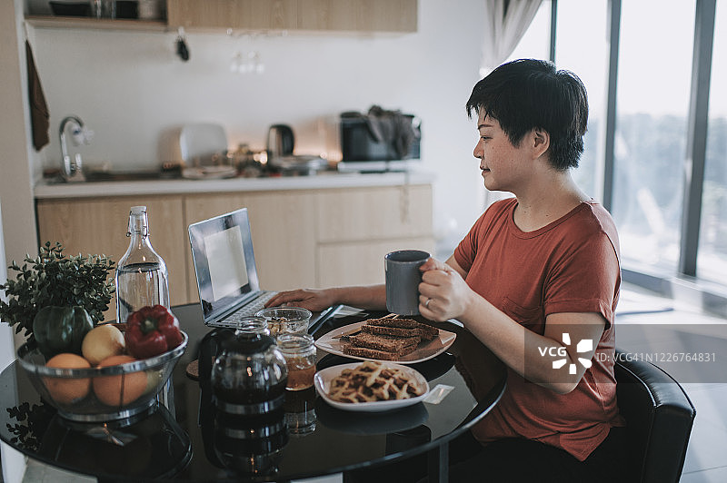 中国中年男子在餐厅用笔记本电脑回复邮件图片素材