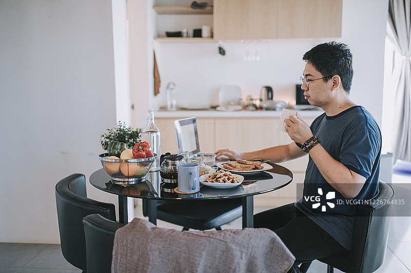 中国中年男子在餐厅用笔记本电脑回复邮件图片素材