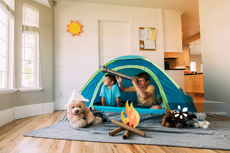 男孩在室内用望远镜探索图片素材