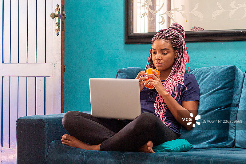 在家里用笔记本的编发年轻黑人女性图片素材