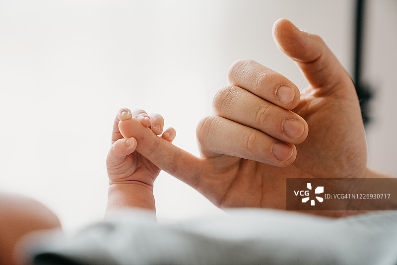 新生婴儿的小手握着父亲的手的细节图片素材
