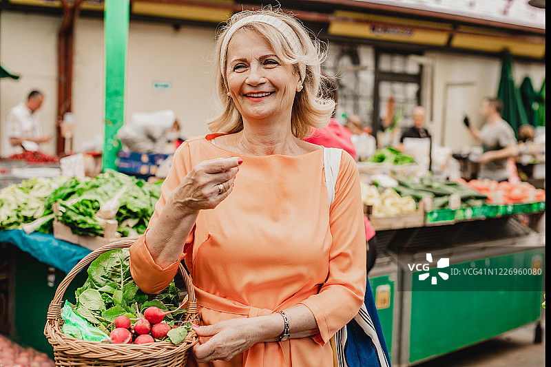 年长的女人在市场上购买食品图片素材