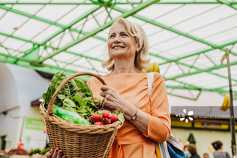 年长的女人在市场上购买食品图片素材