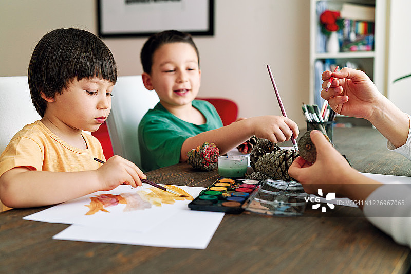 在家一起用水彩绘制松果的可爱家庭图片素材