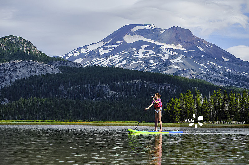 年轻女子在湖上划桨板图片素材