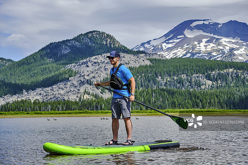 年轻人在湖上划桨板图片素材