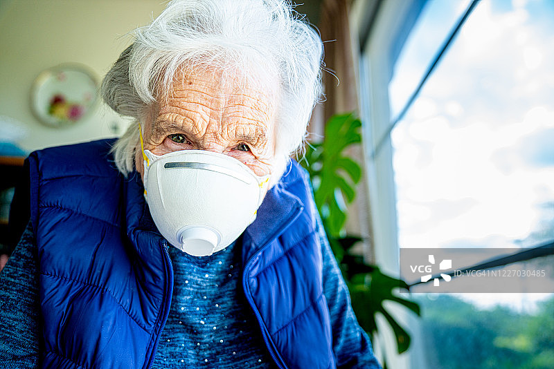 戴着 N95 防护口罩预防流感的年长白人妇女的特写图片素材