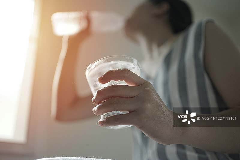 亚洲女性在夏季口渴脱水时喝新鲜水图片素材