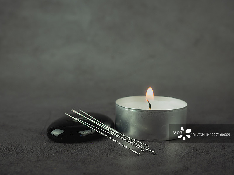 按摩石和茶蜡上的针灸针图片素材