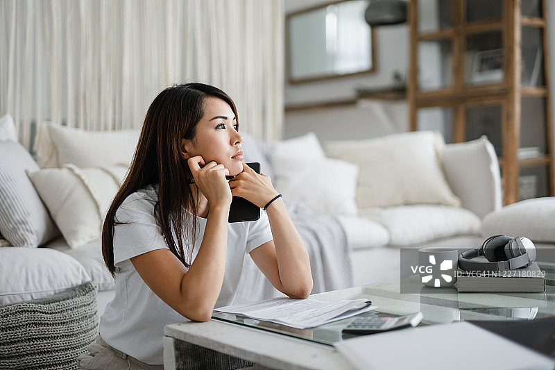 在家工作处理财务的焦虑亚裔年轻女性图片素材