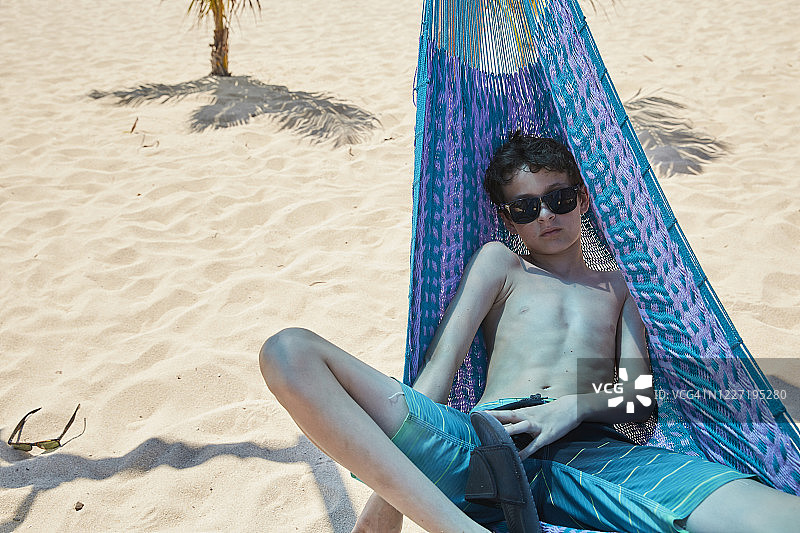 在墨西哥海滩，青少年姐弟在吊床上玩耍图片素材