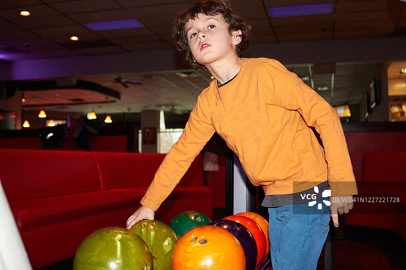小男孩在保龄球馆拿保龄球图片素材