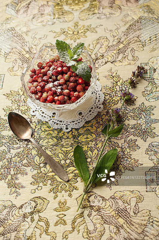 乡村桌上玻璃碗中的新鲜野生草莓图片素材