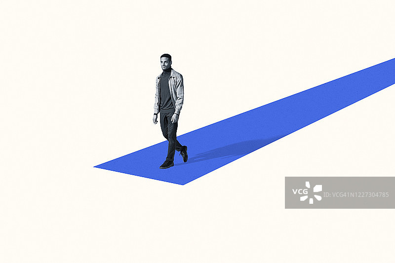自信的年轻男人走在蓝色斜坡上图片素材