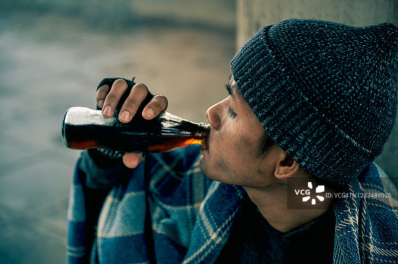 在走道上喝可口可乐的年轻亚洲流浪汉图片素材